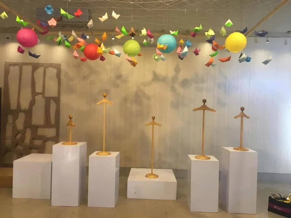 Gallery display with plinths, suspended forms and miniature dresses